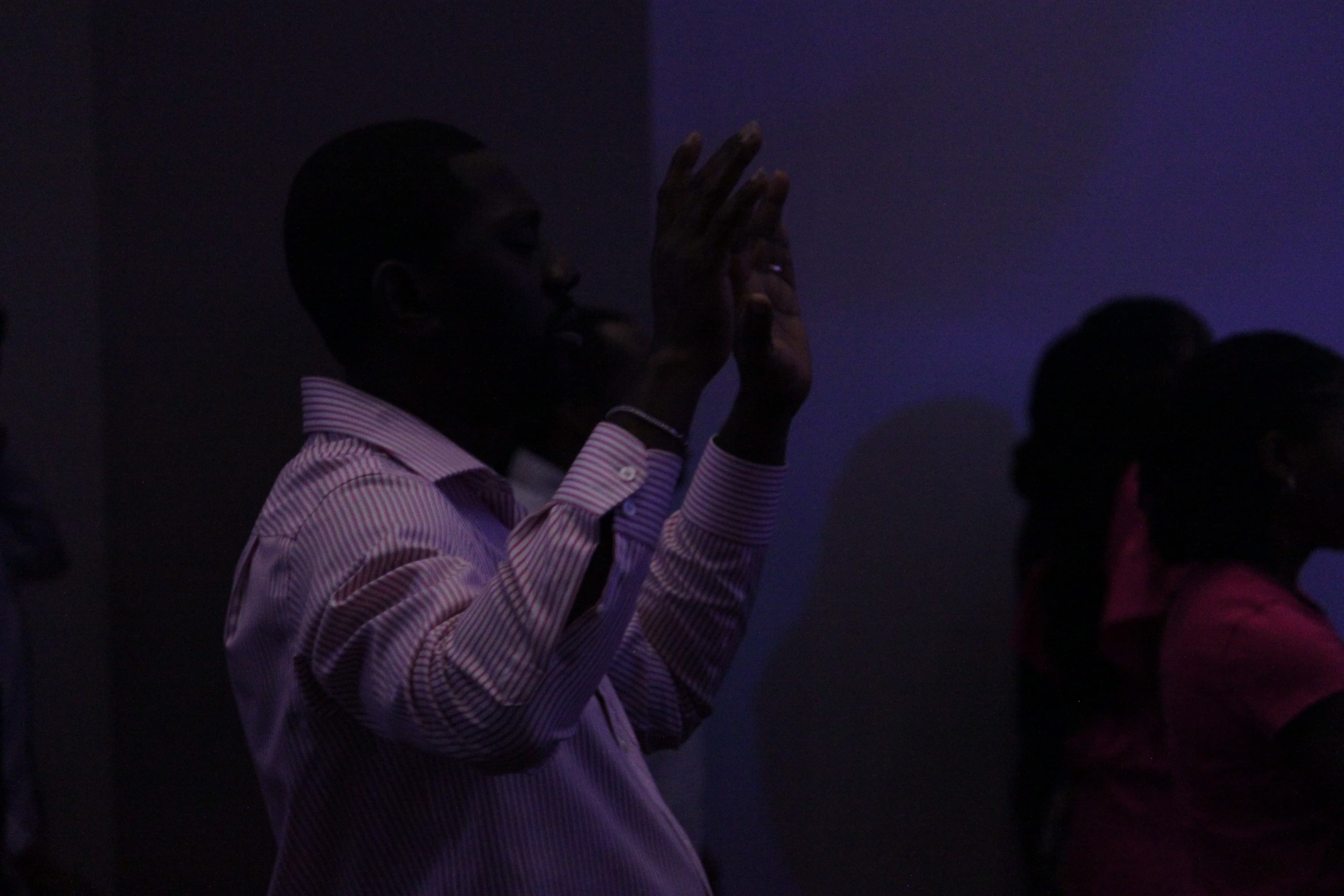 Church member in prayer with hands raised